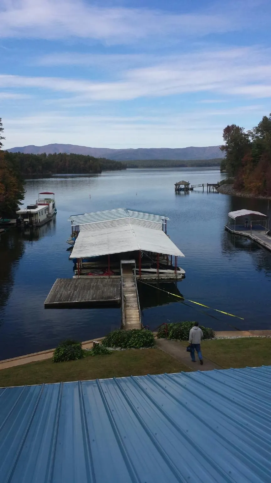 View across a lake from a newly installed blue metal roof in Townville