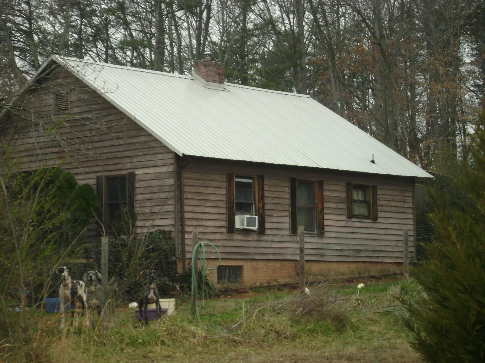 White metal roof on an old wood sided farmhouse, from a Metal Roof Installation job in Townville